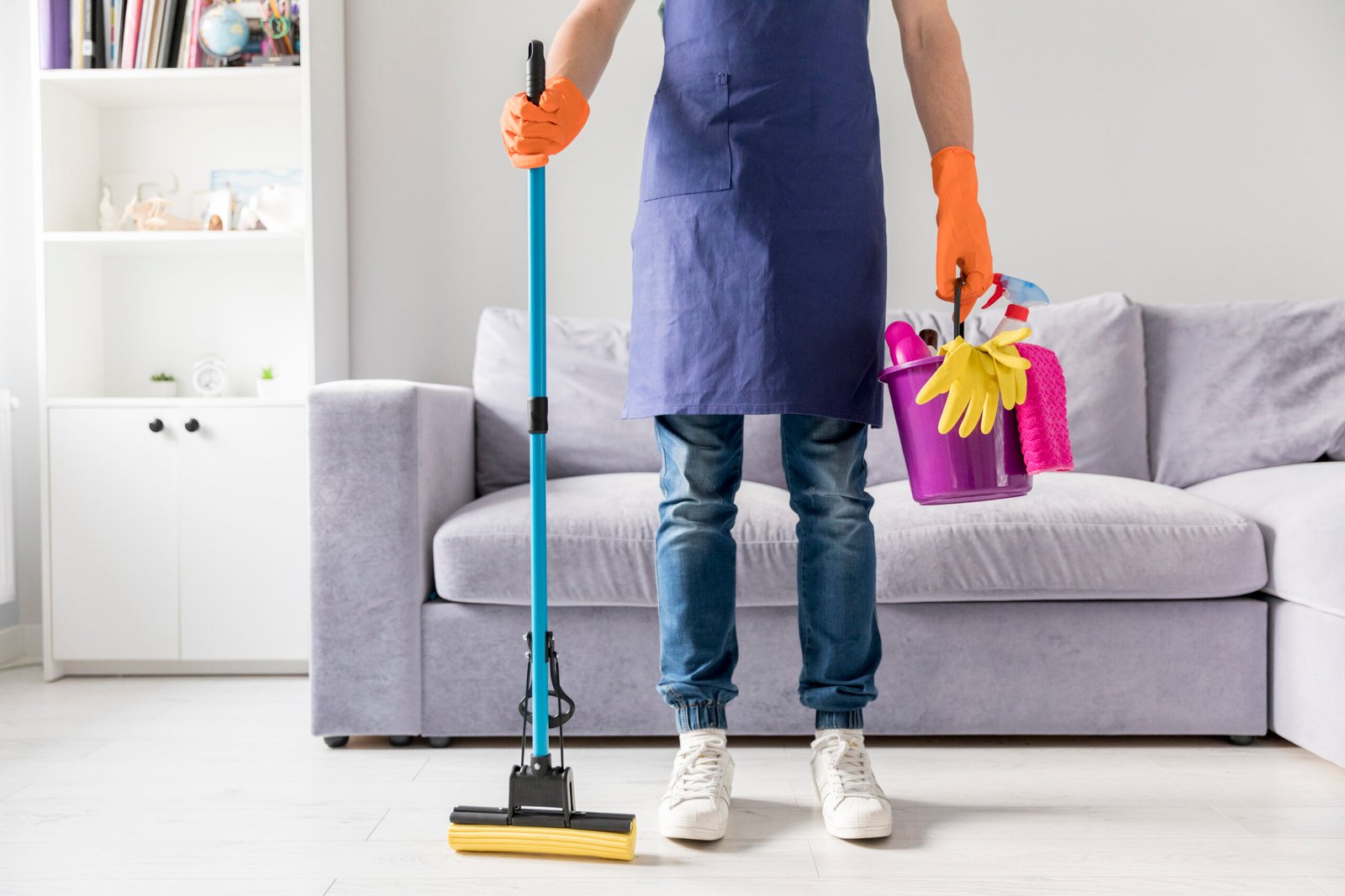 Personne effectuant un nettoyage avec des gants et des produits ménagers dans un salon moderne